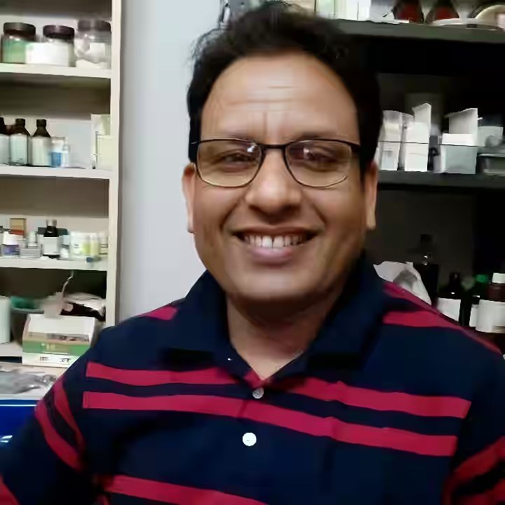 Dr. B. D. Verma at Arogya Ayurvedic Chikitsalay with medicine shelves behind