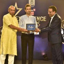 Dr. Verma receiving an excellence award on stage