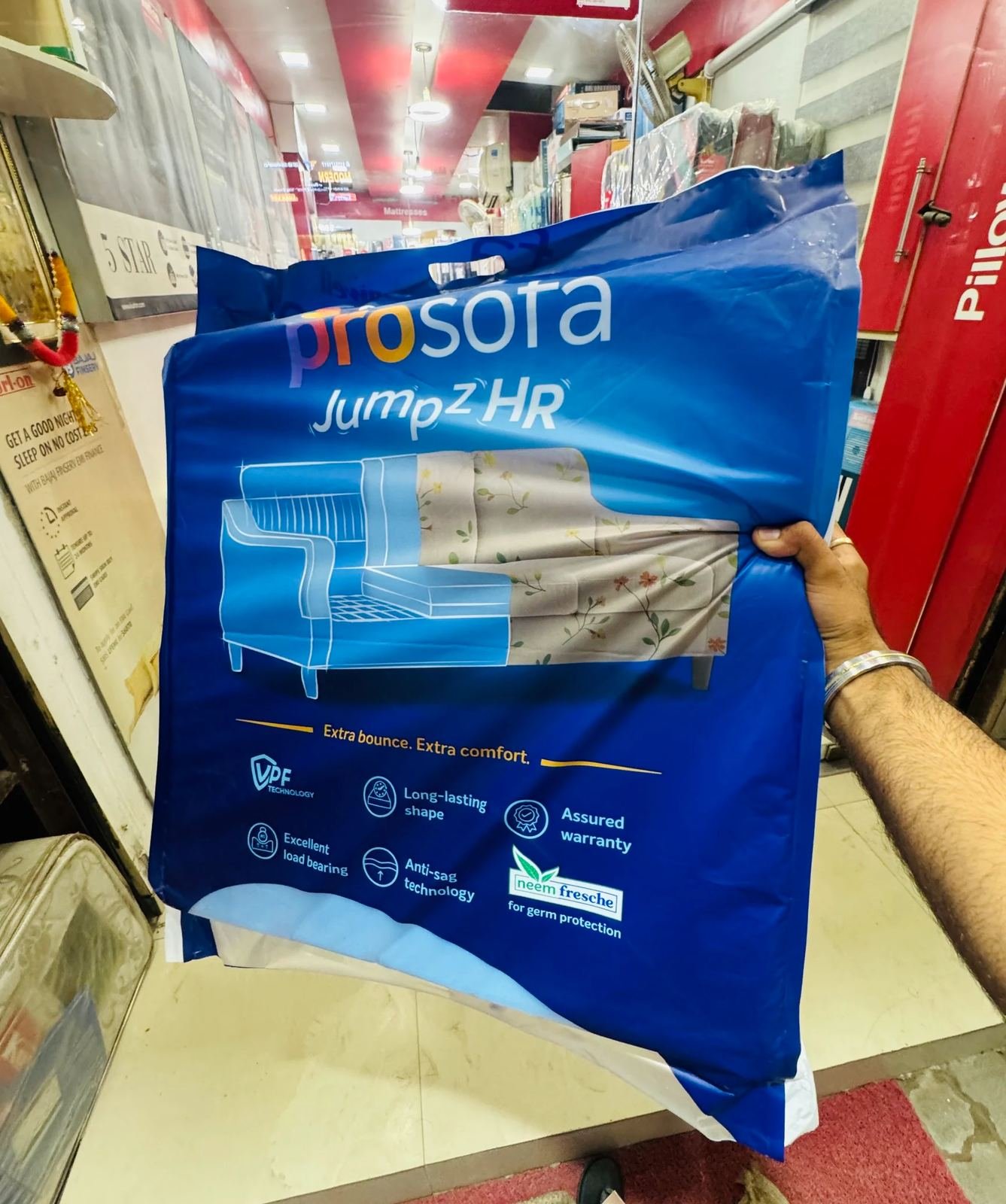 Customer holding a foam mattress pack inside Harsh Foam Agencies store, Lucknow