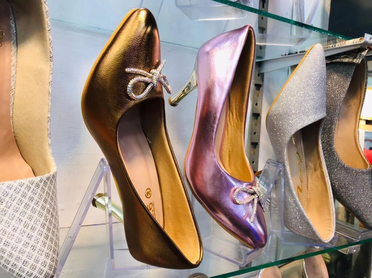 Metallic pumps and glitter heels on shelf