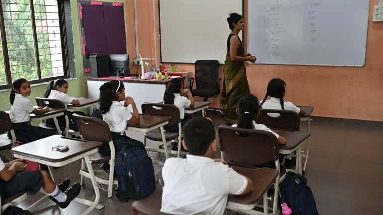 Teacher explaining concepts at a whiteboard in a Mangalam Academy classroom