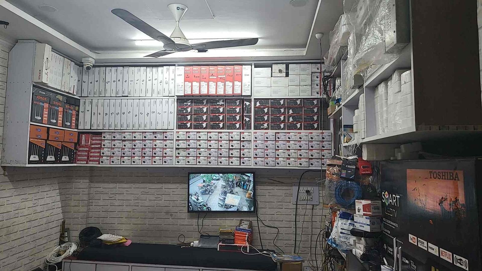 Shop interior with camera stock wall and live monitor — repair & upgrade in Indira Nagar, Lucknow