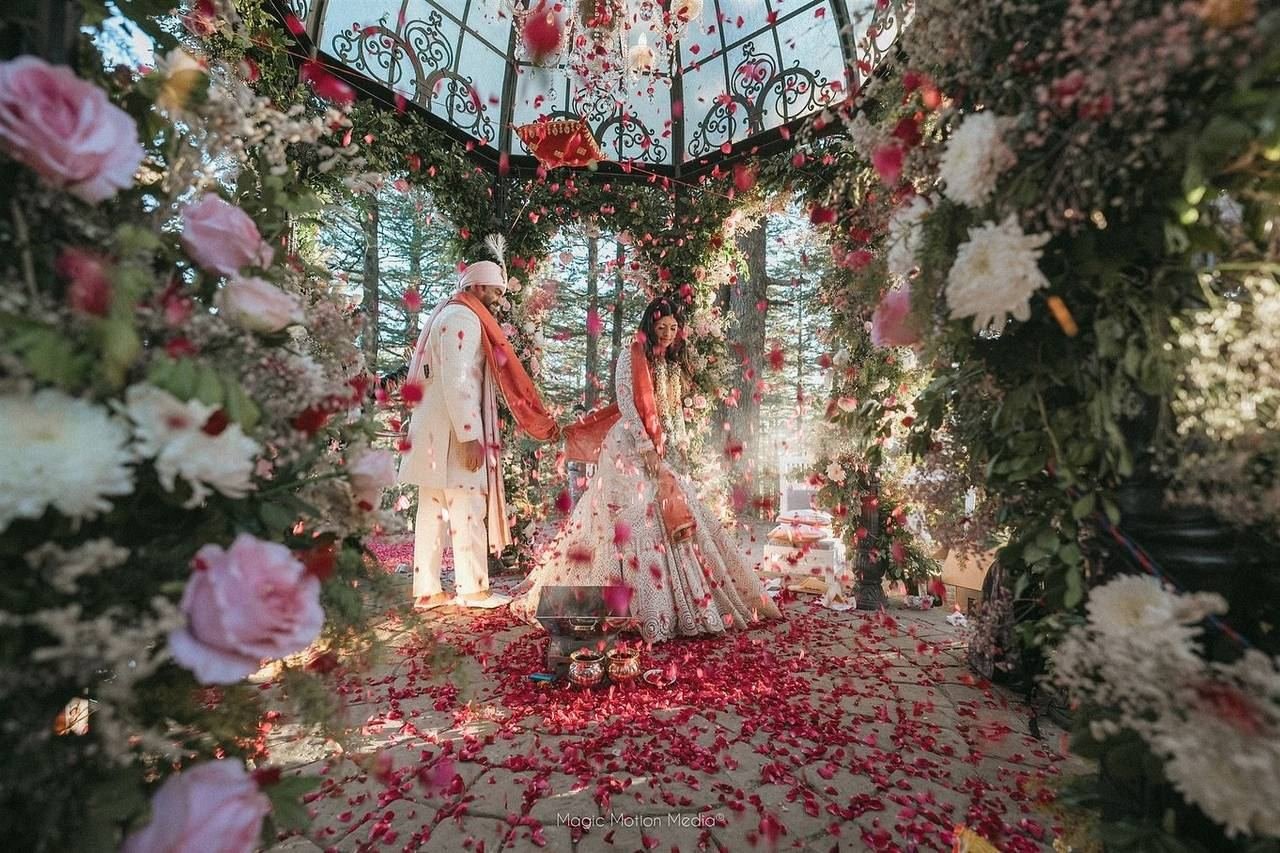 Bride and groom in floral glass mandap decor by Nits Events, Lucknow wedding