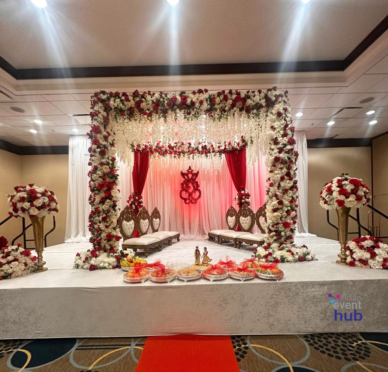 Reception stage mandap with red and white floral decor by Nits Events