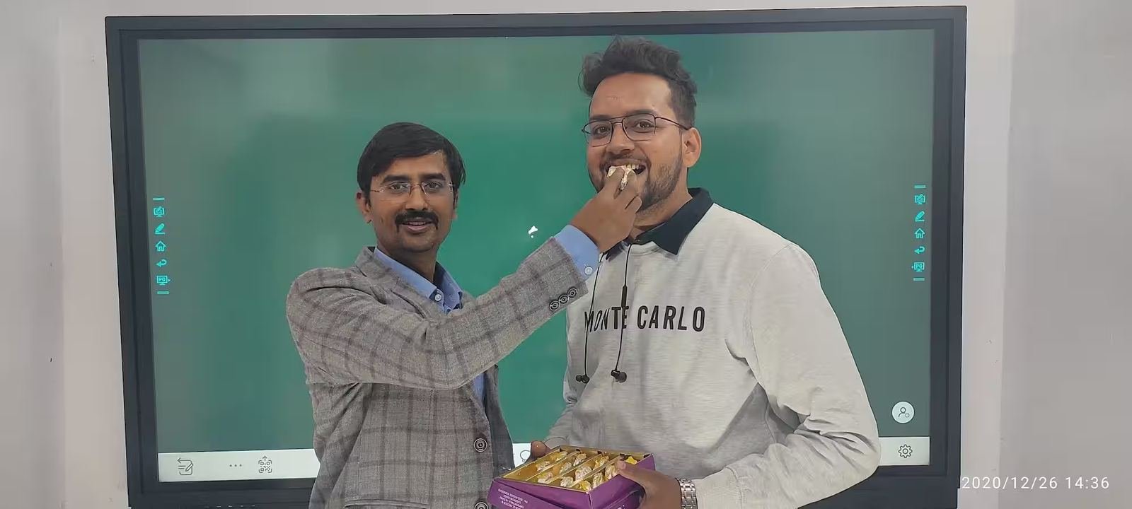 Teacher explaining a concept to a student at the smart board