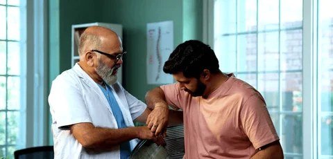 Physiotherapist treating a patient's arm during a manual therapy session