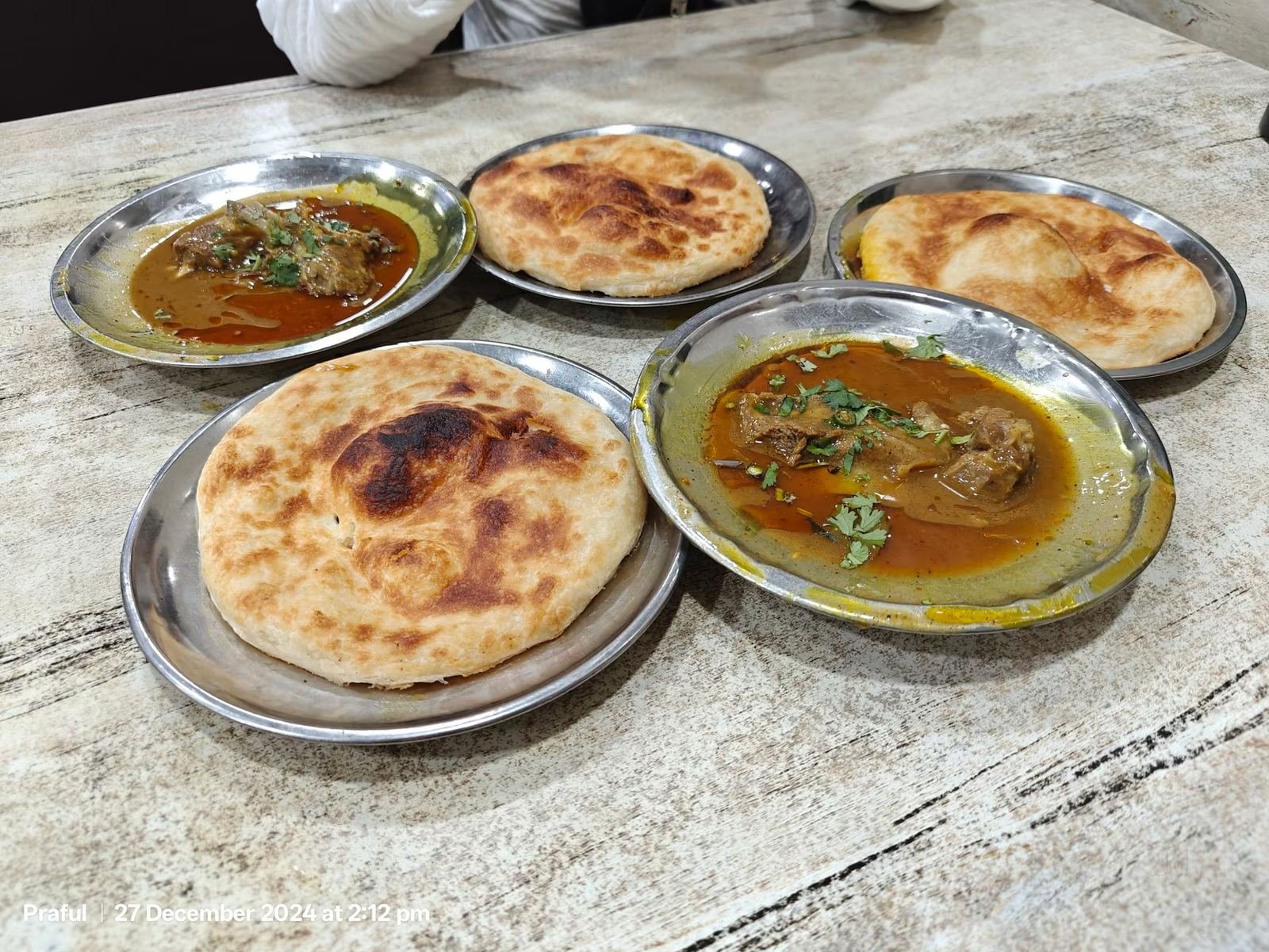 Kulcha and nihari plates spread on table at Raheem's Kulcha Nahari, Chowk Lucknow