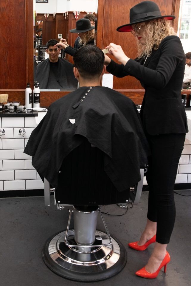 Barber styling men haircut at station