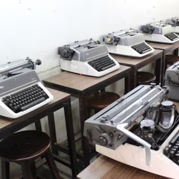 Typewriters arranged on classroom desks