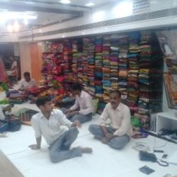 Shop interior of Vipin Sarees with staff and saree stacks
