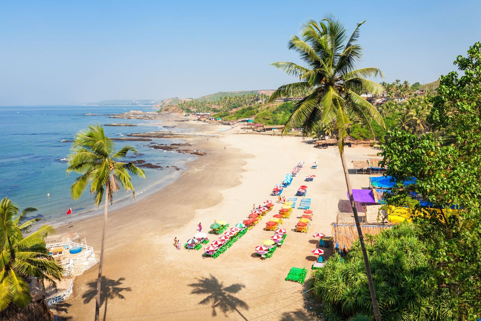 Aerial view of a Goa beach with palm trees and shacks, holiday package by Yarana Tours and Tourism, travel agent in Aashiyana Lucknow