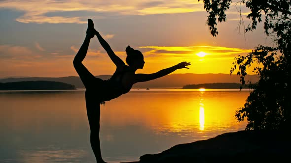 Yoga pose by the lake at golden hour